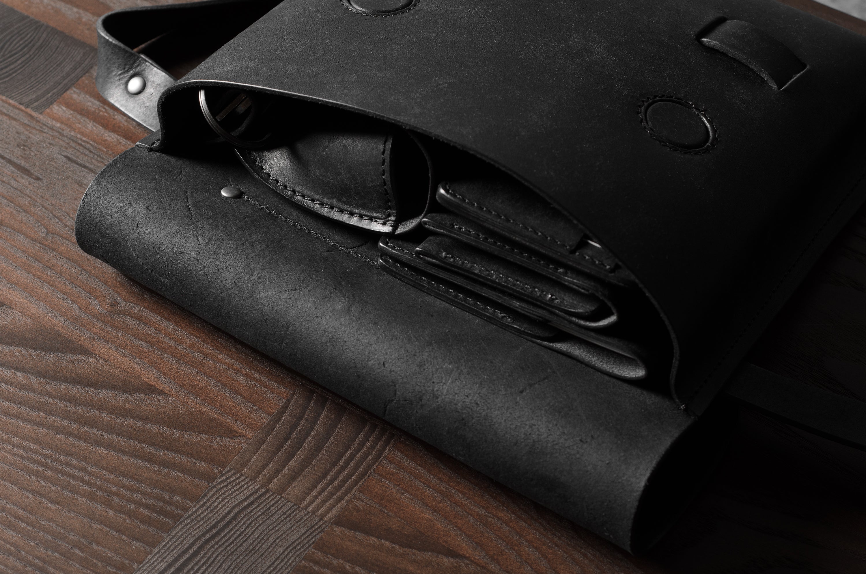 Black leather bag on a wooden surface