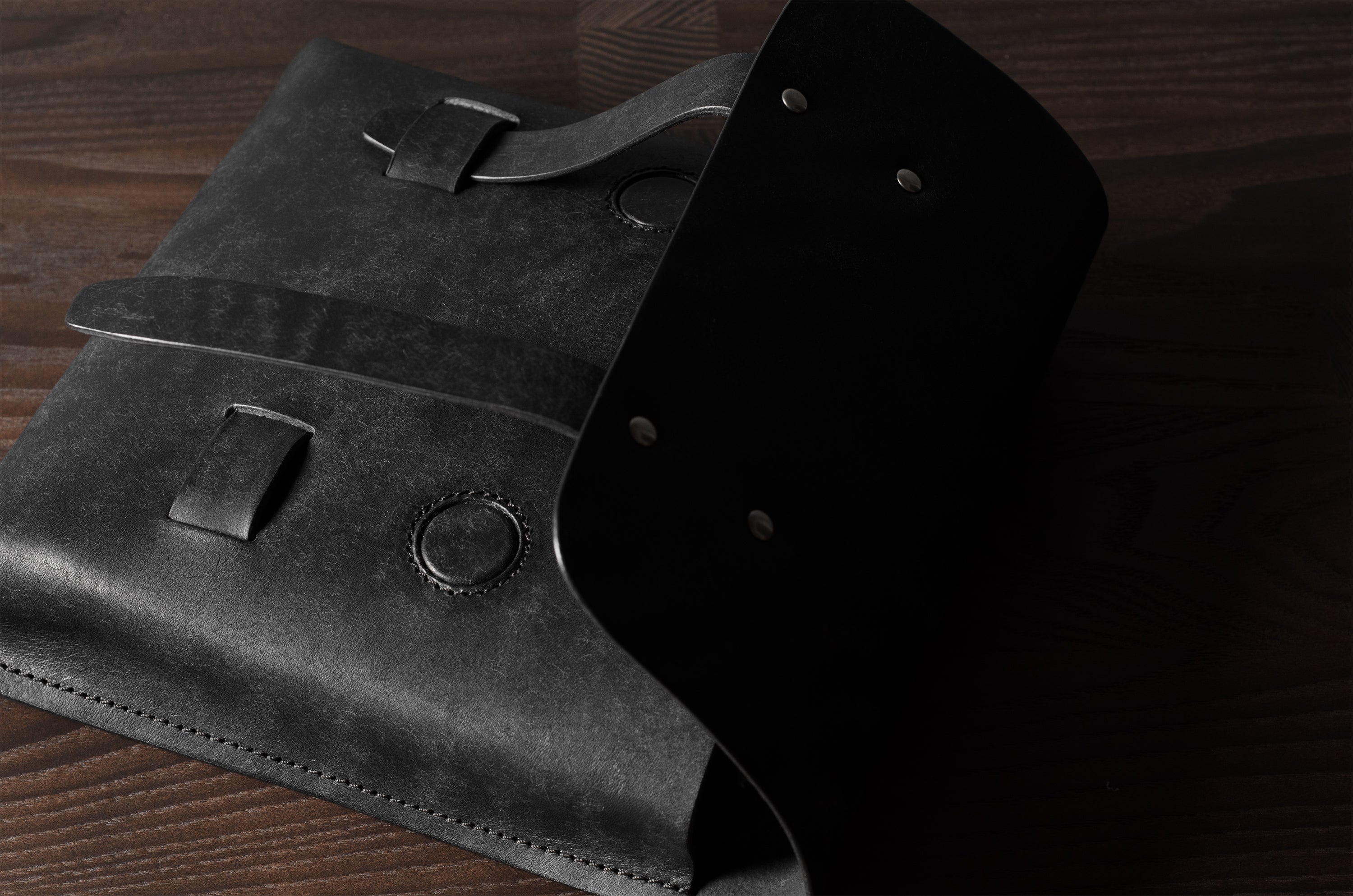 Black leather bag on a wooden surface