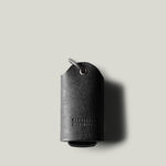 Black leather key holder with keyring on light grey background