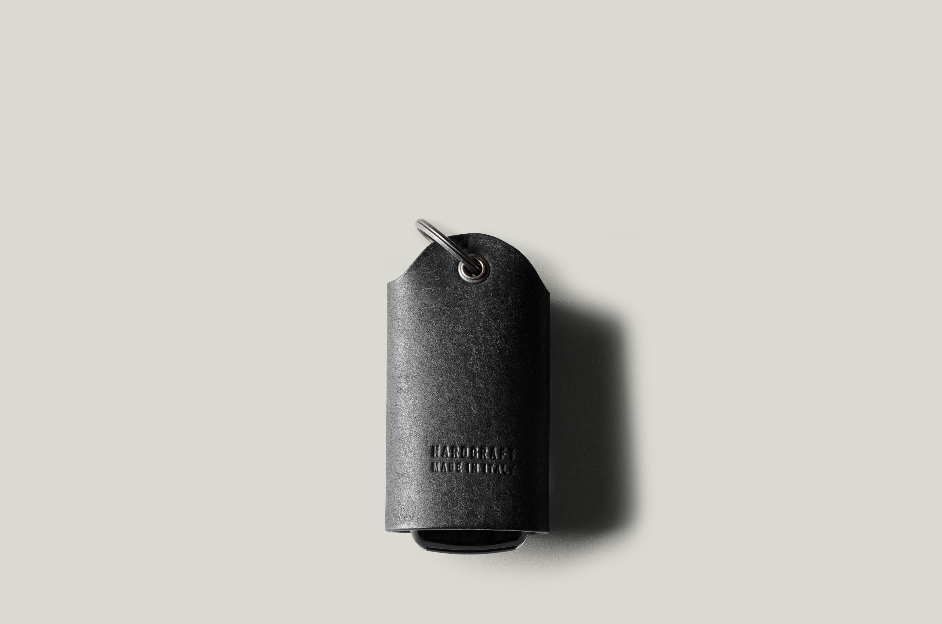 Black leather key holder with keyring on light grey background