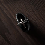 Black leather key holder with keyring on wood background