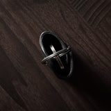 Black leather key holder with keyring on wood background