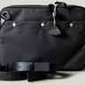 A charcoal-colored laptop bag with black leather straps and a brown wool-blend lining. It features a main compartment closed with a zipper and an additional exterior pocket.