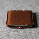 Brown leather cardholder on a gray textured background
