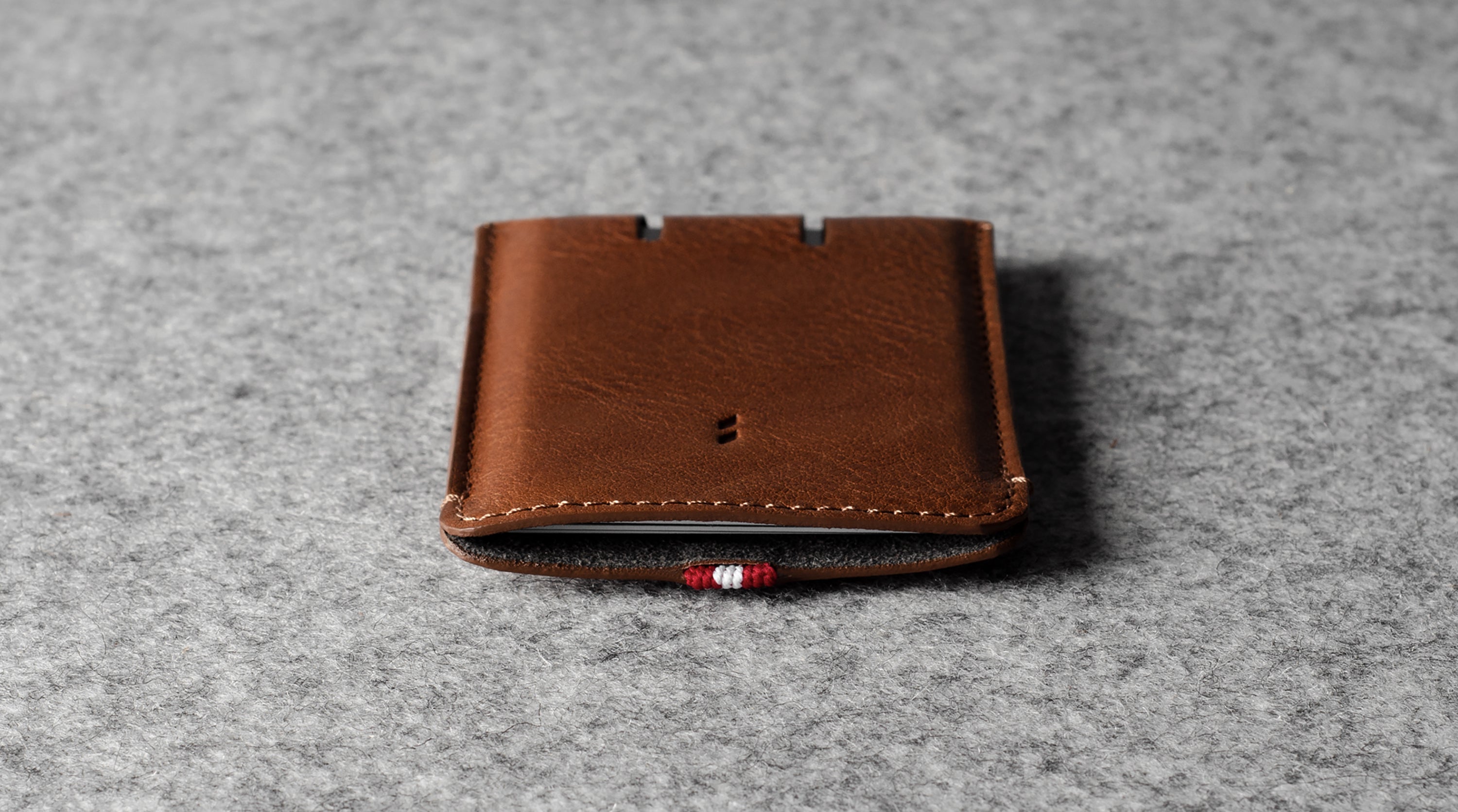 Brown leather cardholder on a gray textured background