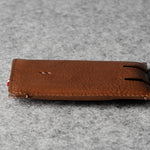 Brown leather wallet on a gray textured surface