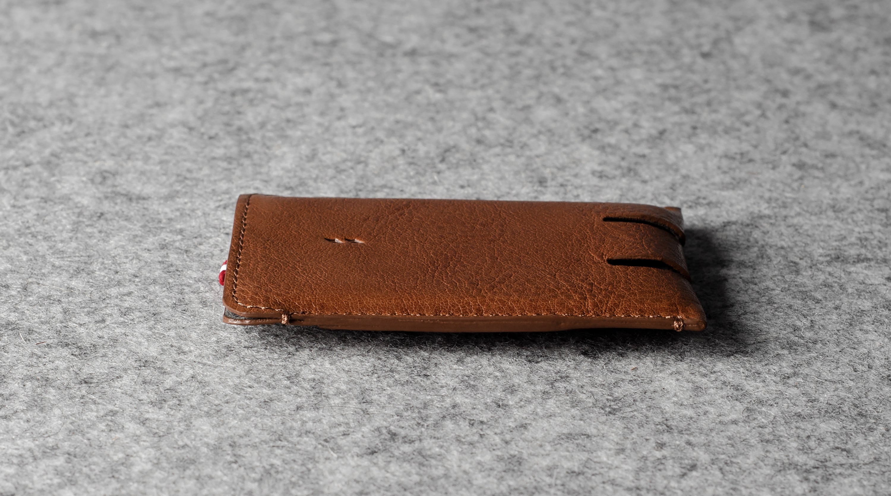 Brown leather wallet on a gray textured surface