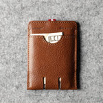 Brown leather cardholder on a gray textured background