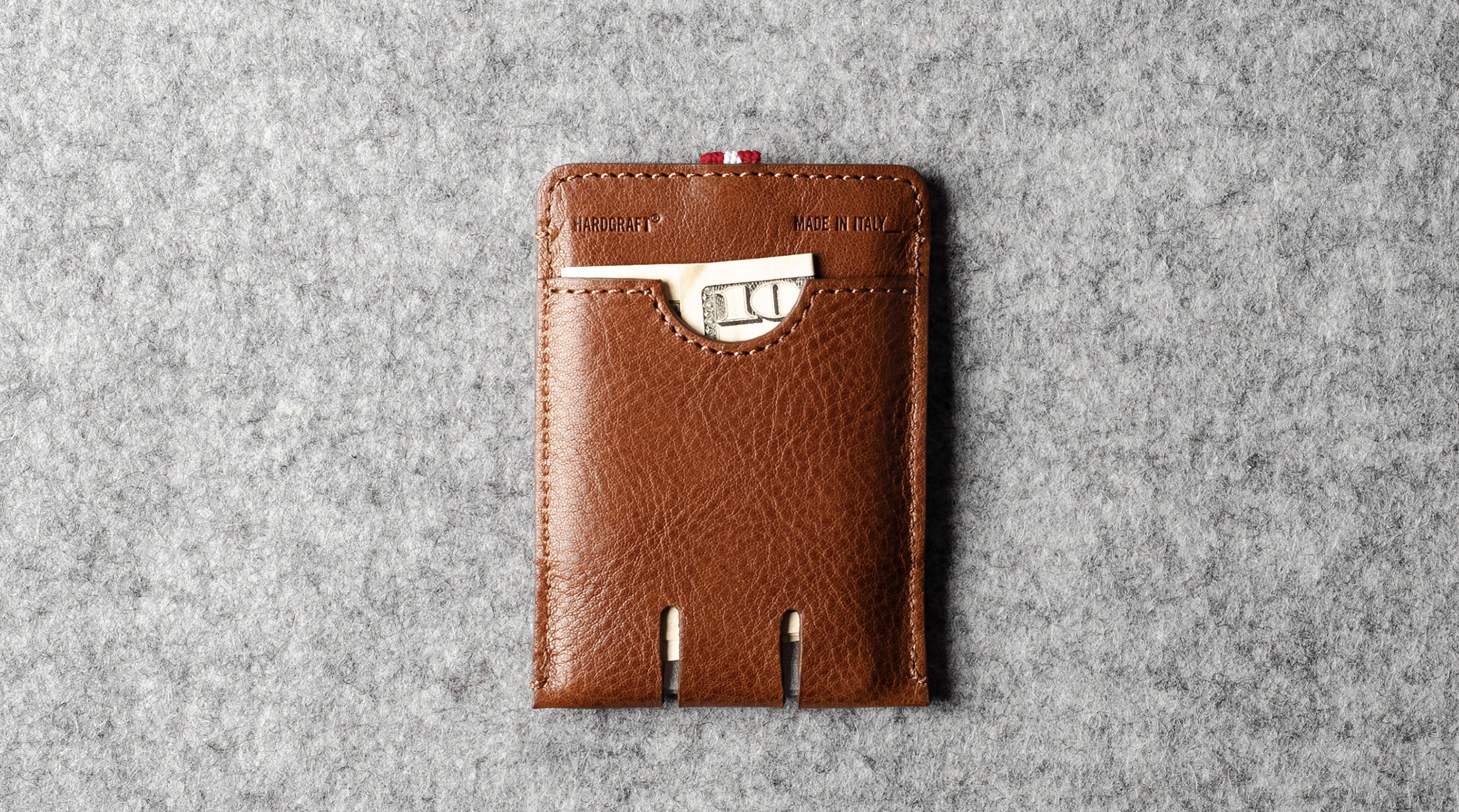 Brown leather cardholder on a gray textured background