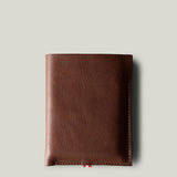 A brown leather iPhone Duo Case with a pebbled texture, shown closed against a solid light gray background.