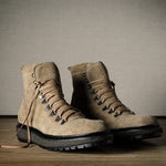 Pair of brown hiking boots on a wooden floor with a neutral background