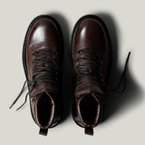 Brown leather hike boots on light grey background.
