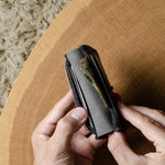 Person holding a wallet on a wooden surface with a textured background