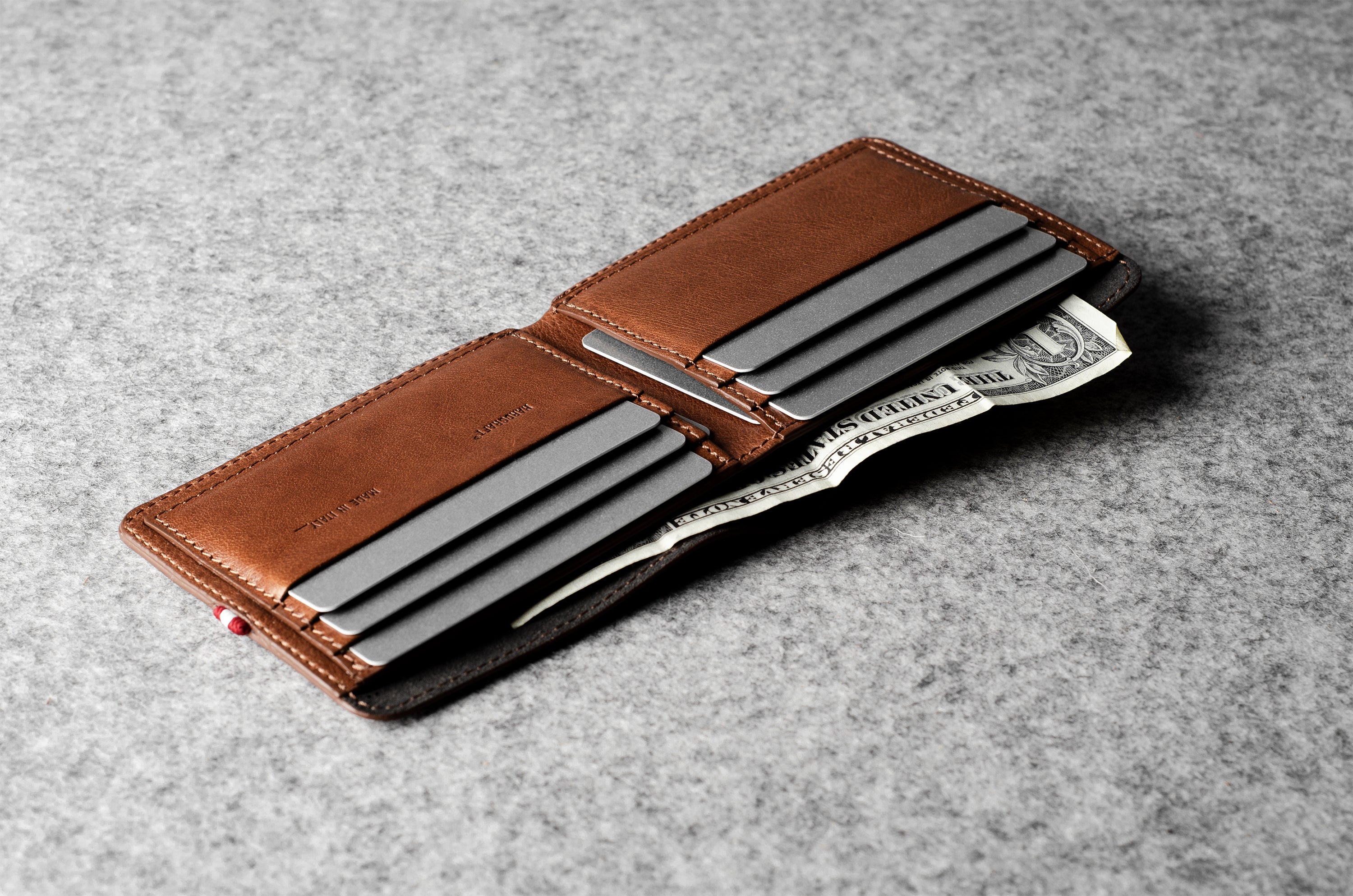 Brown leather wallet with money clip on a gray surface