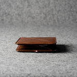 Brown leather wallet on a gray textured surface
