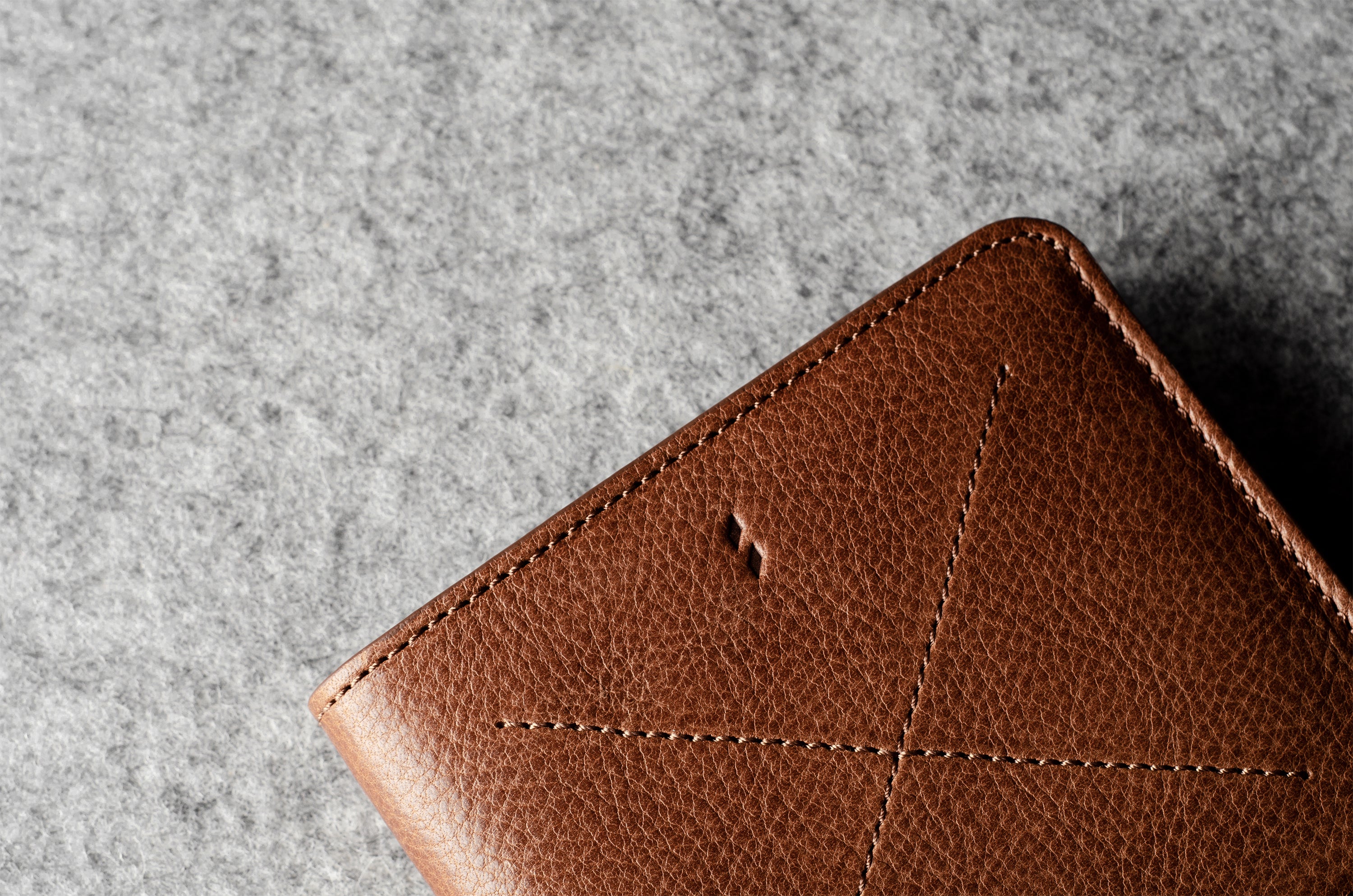 Brown leather wallet on a gray textured surface