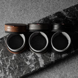Three open leather watch cases on a marble surface