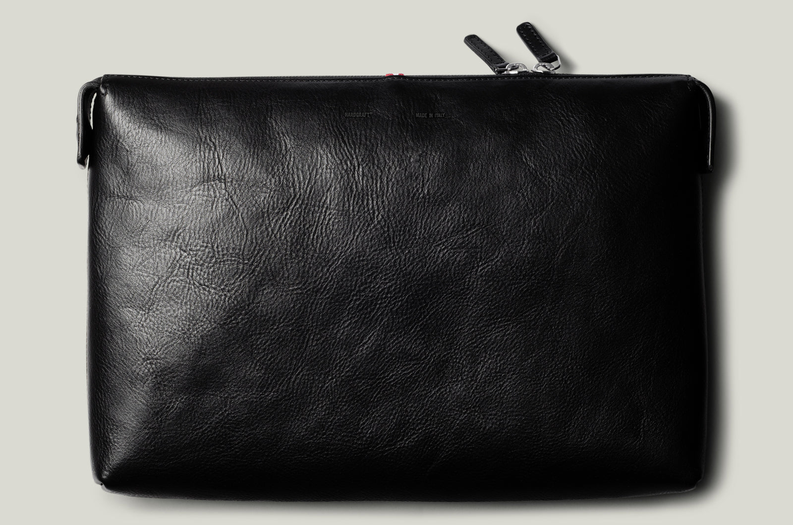 Black leather pouch with a zipper on a light gray background