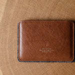 Brown leather passport wallet on a wooden surface