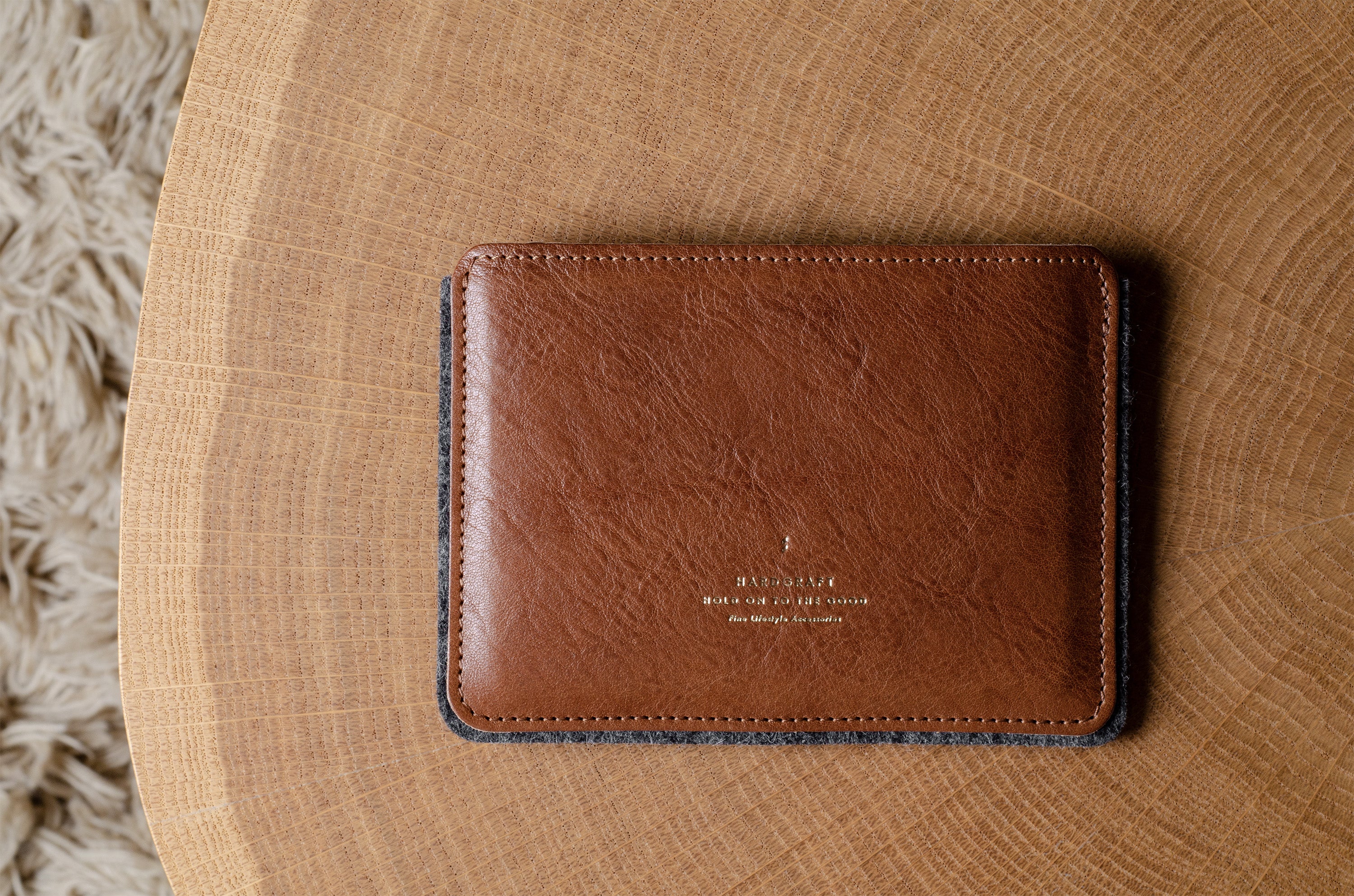 Brown leather passport wallet on a wooden surface