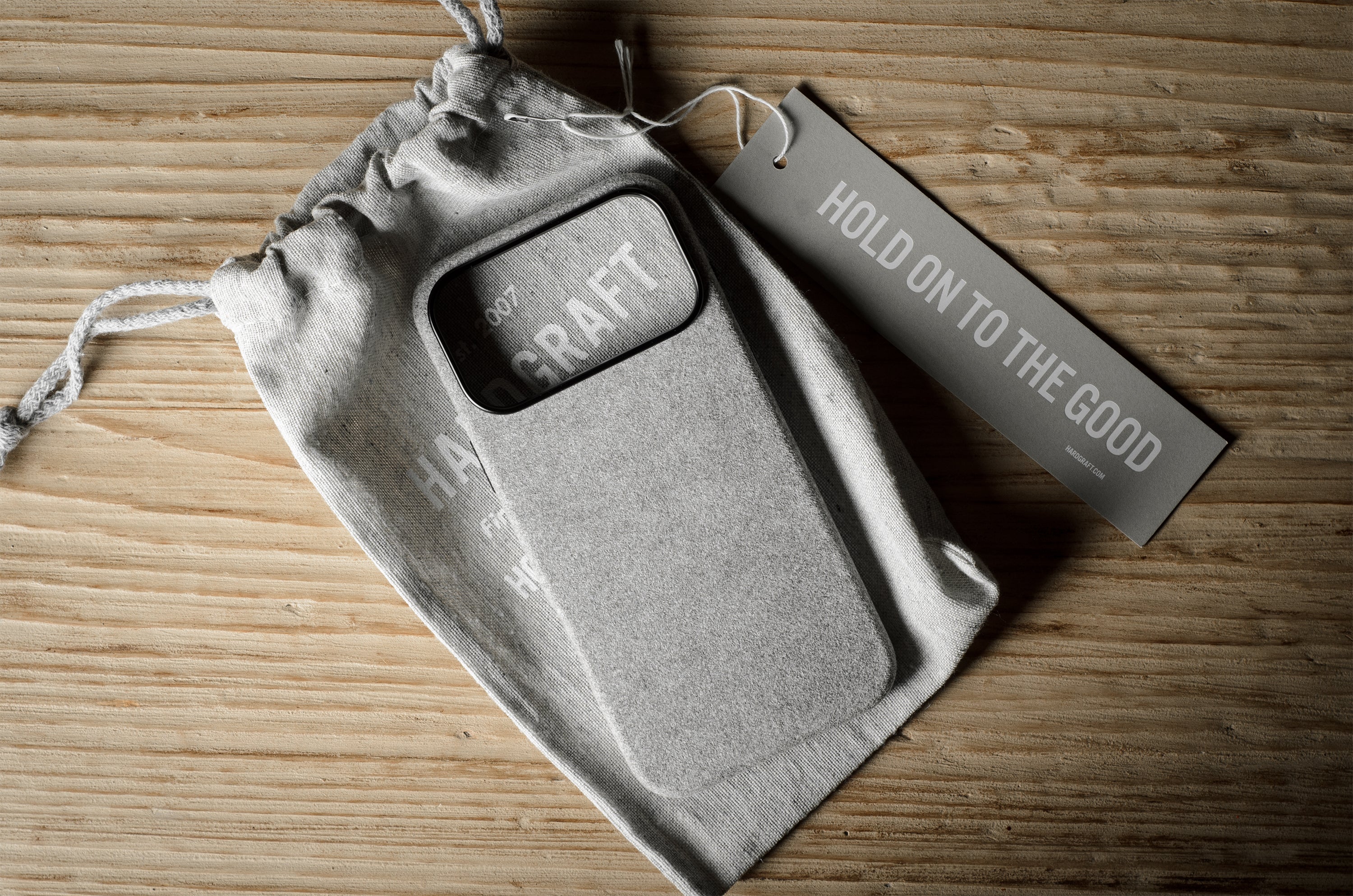 Gray iPhone case with 'Craft' branding on a wooden surface