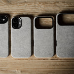 Four gray pihone cases on a wooden surface