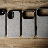 Four gray pihone cases on a wooden surface