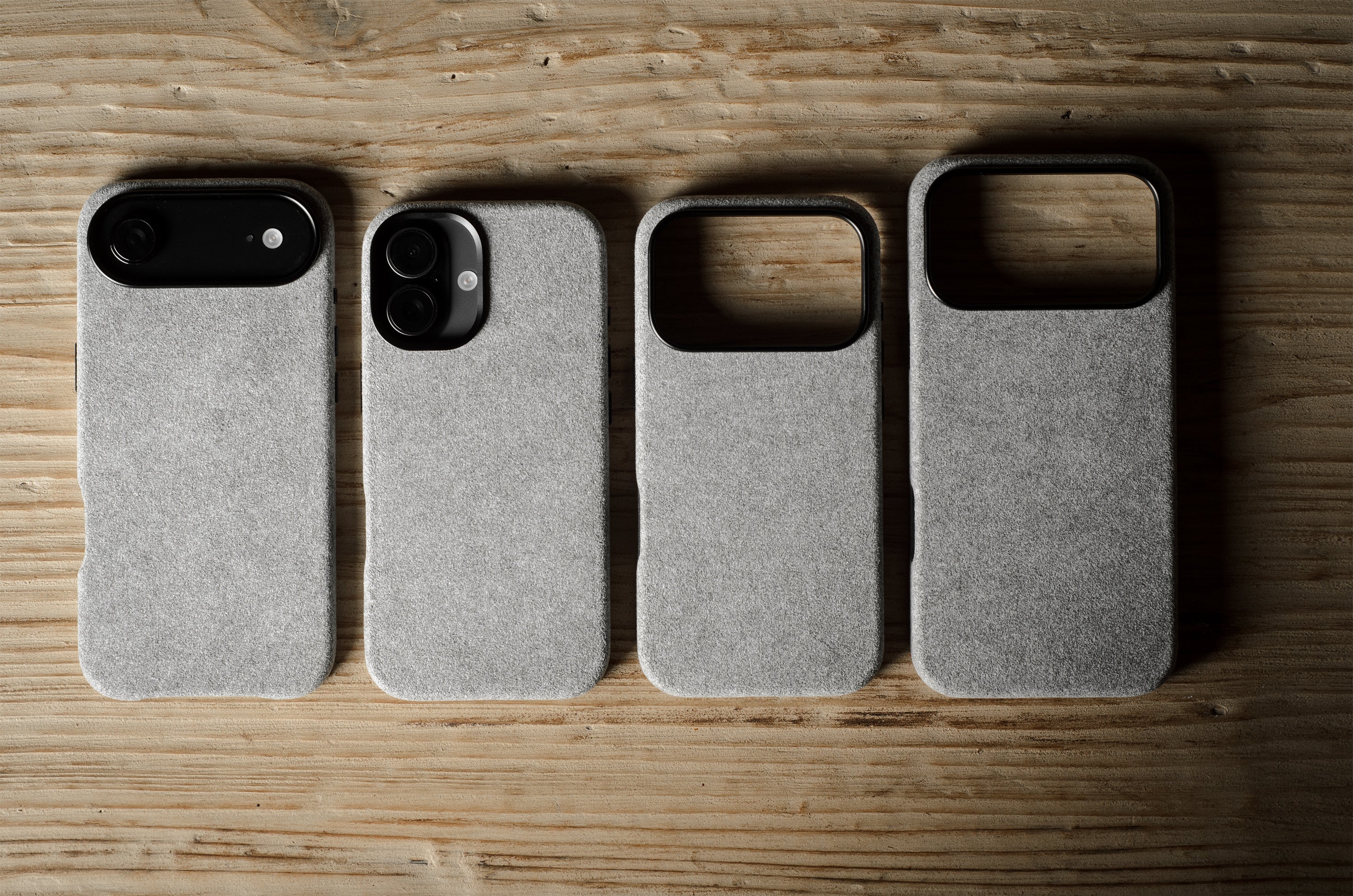 Four gray pihone cases on a wooden surface
