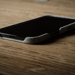 iPhone with a textured case on a wooden surface