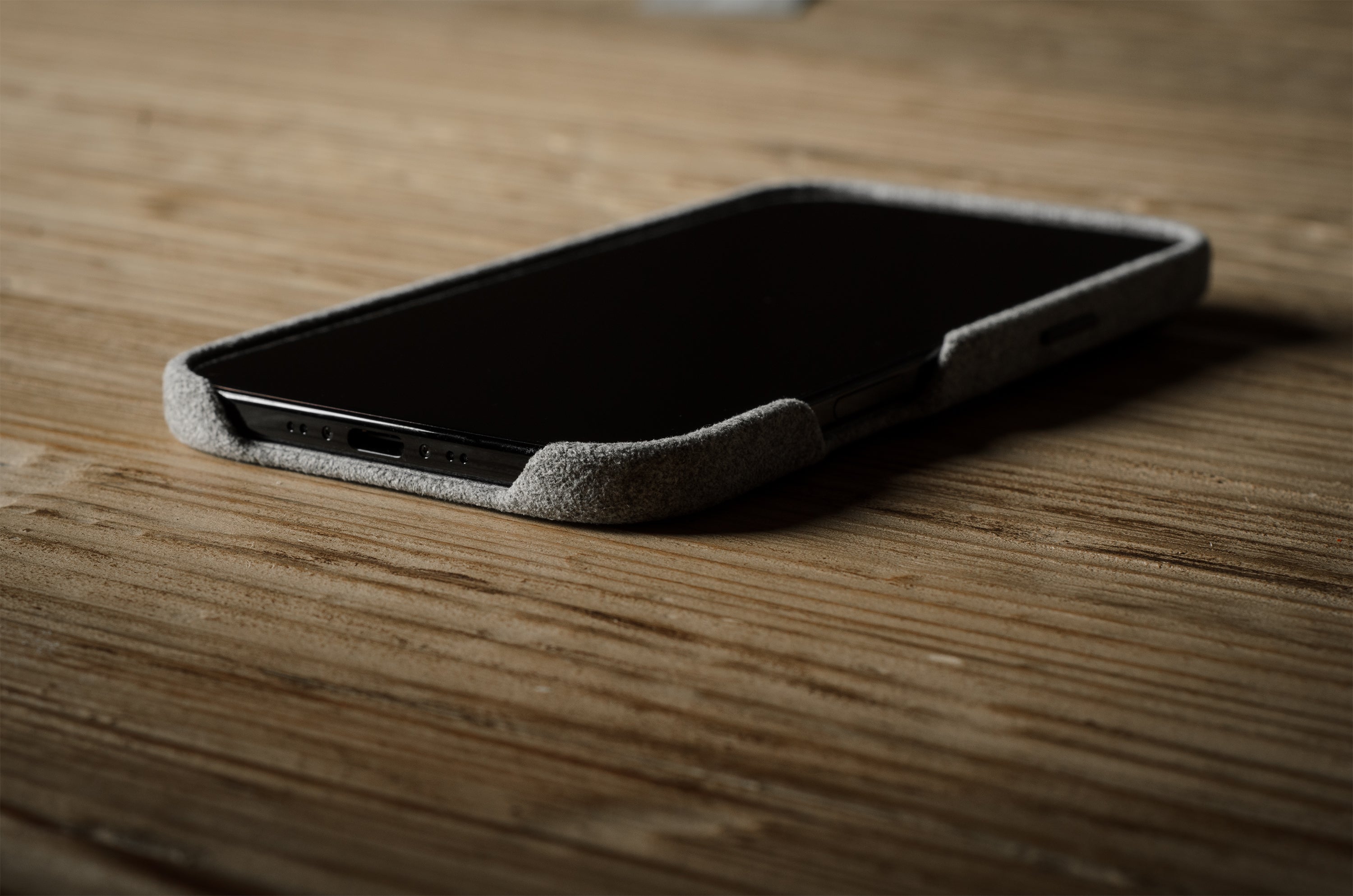 iPhone with a textured case on a wooden surface