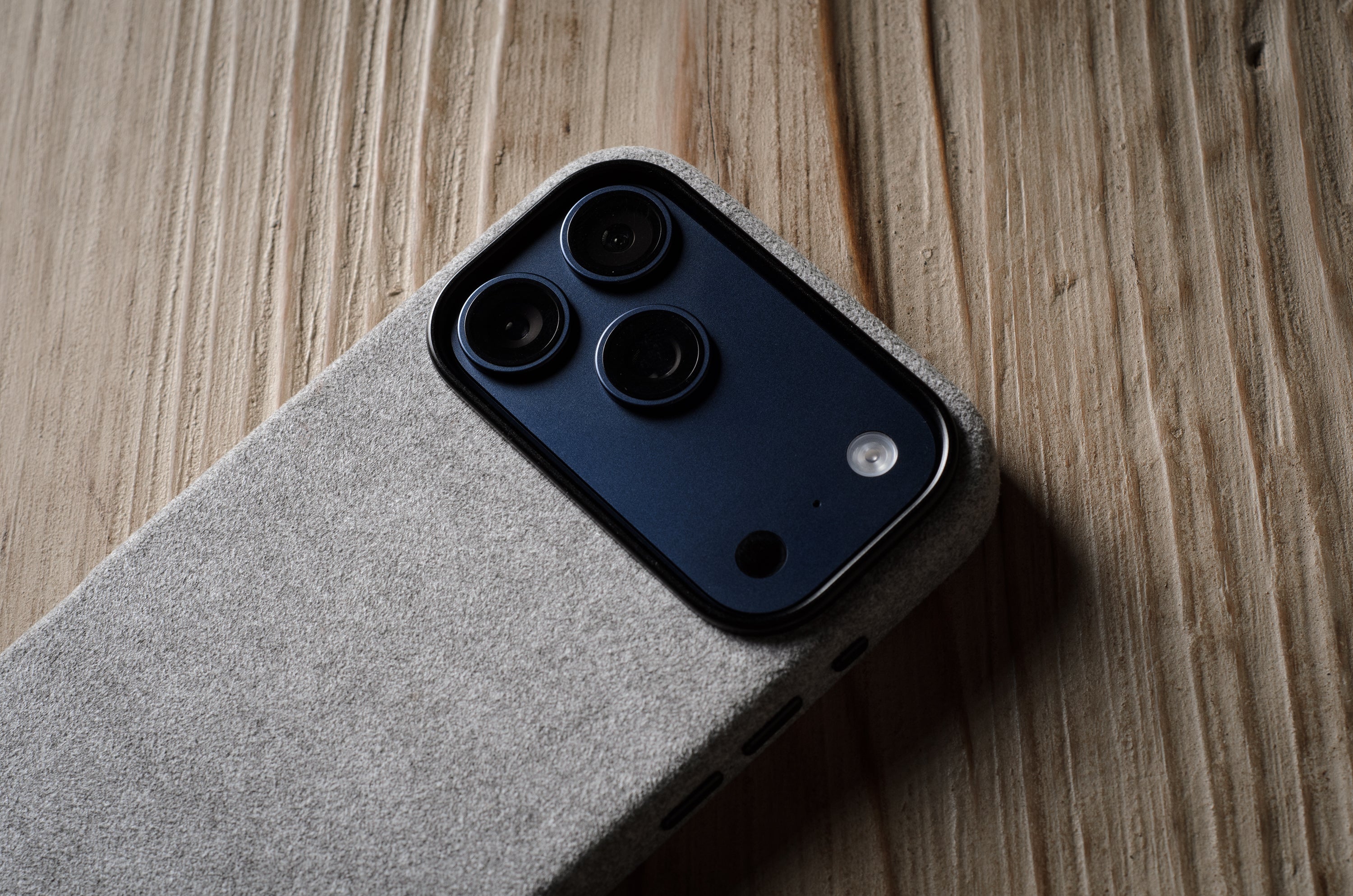 iPhone with a grey back cover on a wooden surface