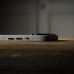 Close-up of a iPhone side profile on a wooden surface with a dark background
