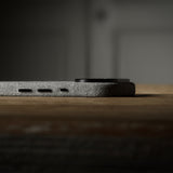 Close-up of a iPhone side profile on a wooden surface with a dark background