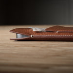Brown leather  iphone case on a wooden surface with a blurred background