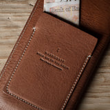 Brown leather  iphone case with visible branding on a wooden surface