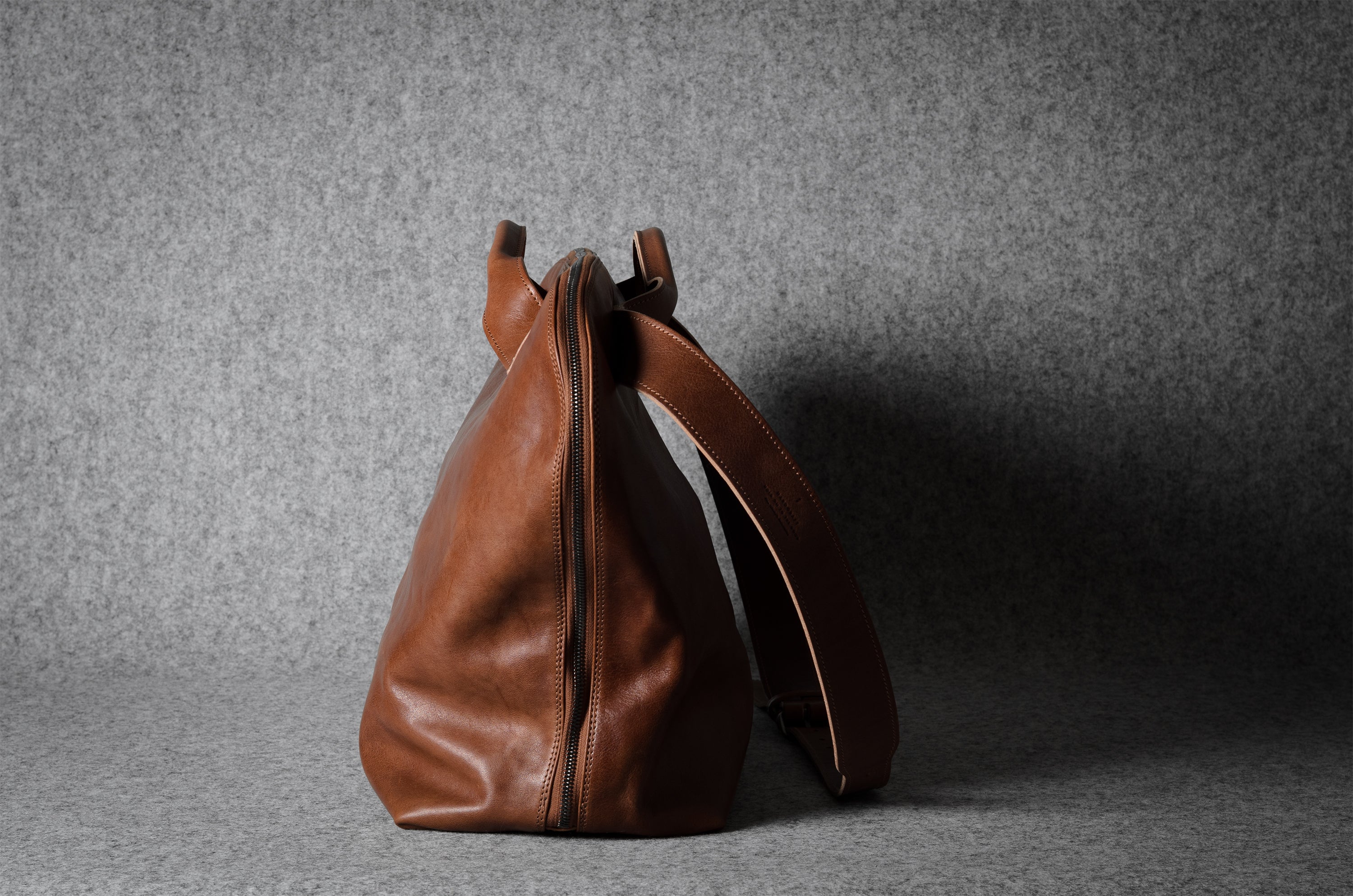 Brown leather bag on a gray background