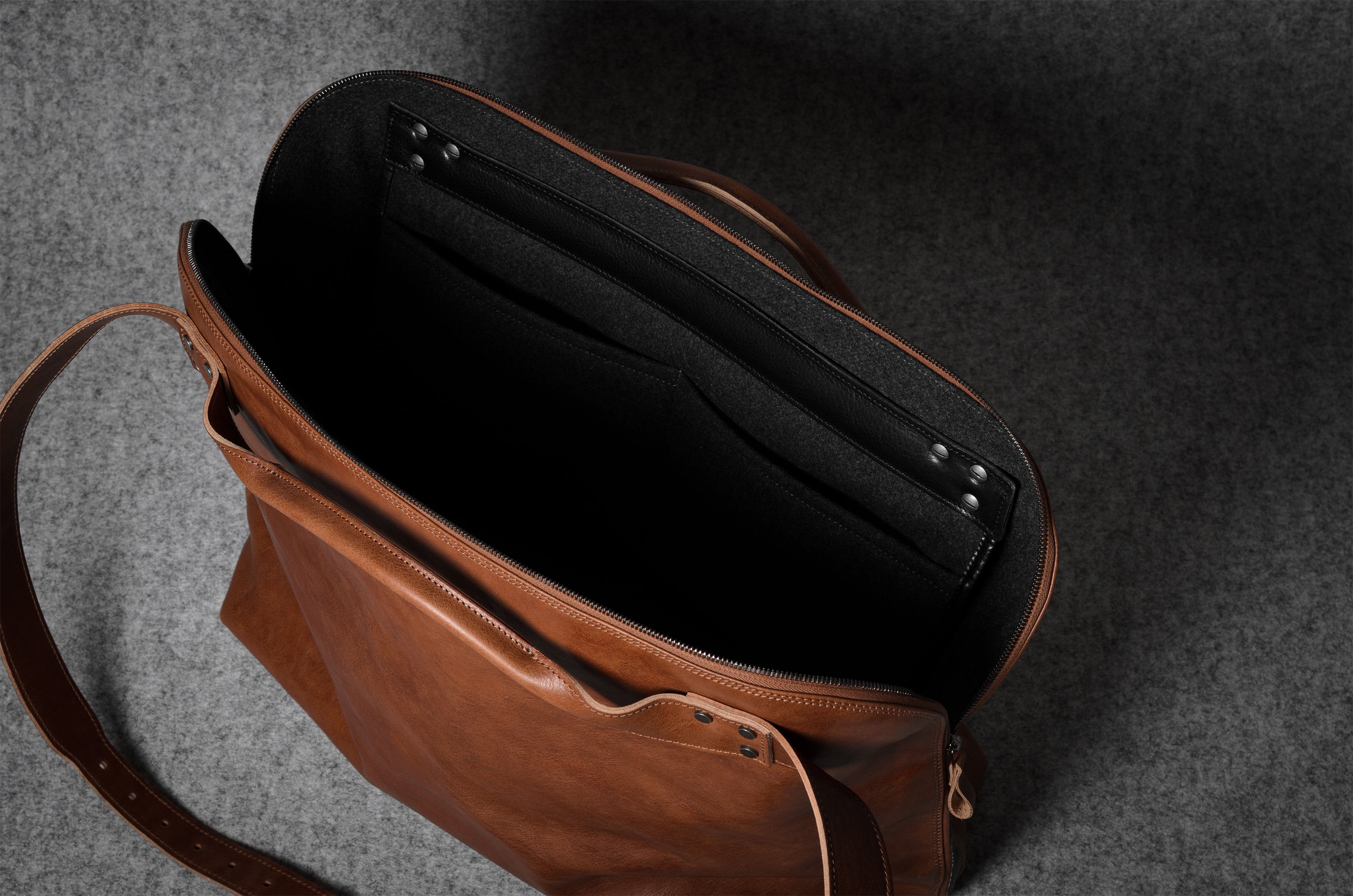 Brown leather bag with a grey interior on a dark gray background