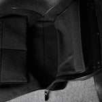 Black leather bag with a strap on a gray background