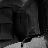 Black leather bag with a strap on a gray background