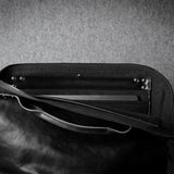 Black leather bag with a textured gray background