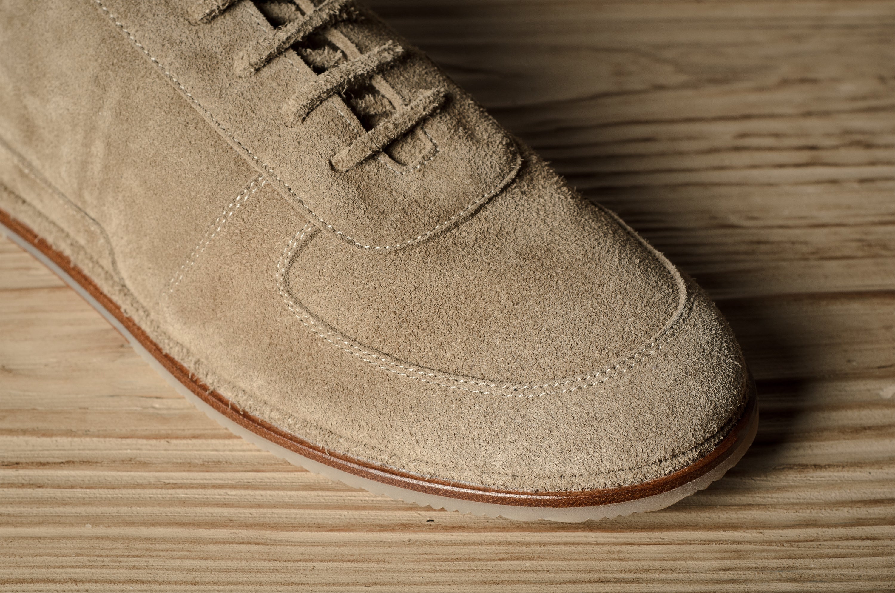 Beige suede shoe on a wooden surface