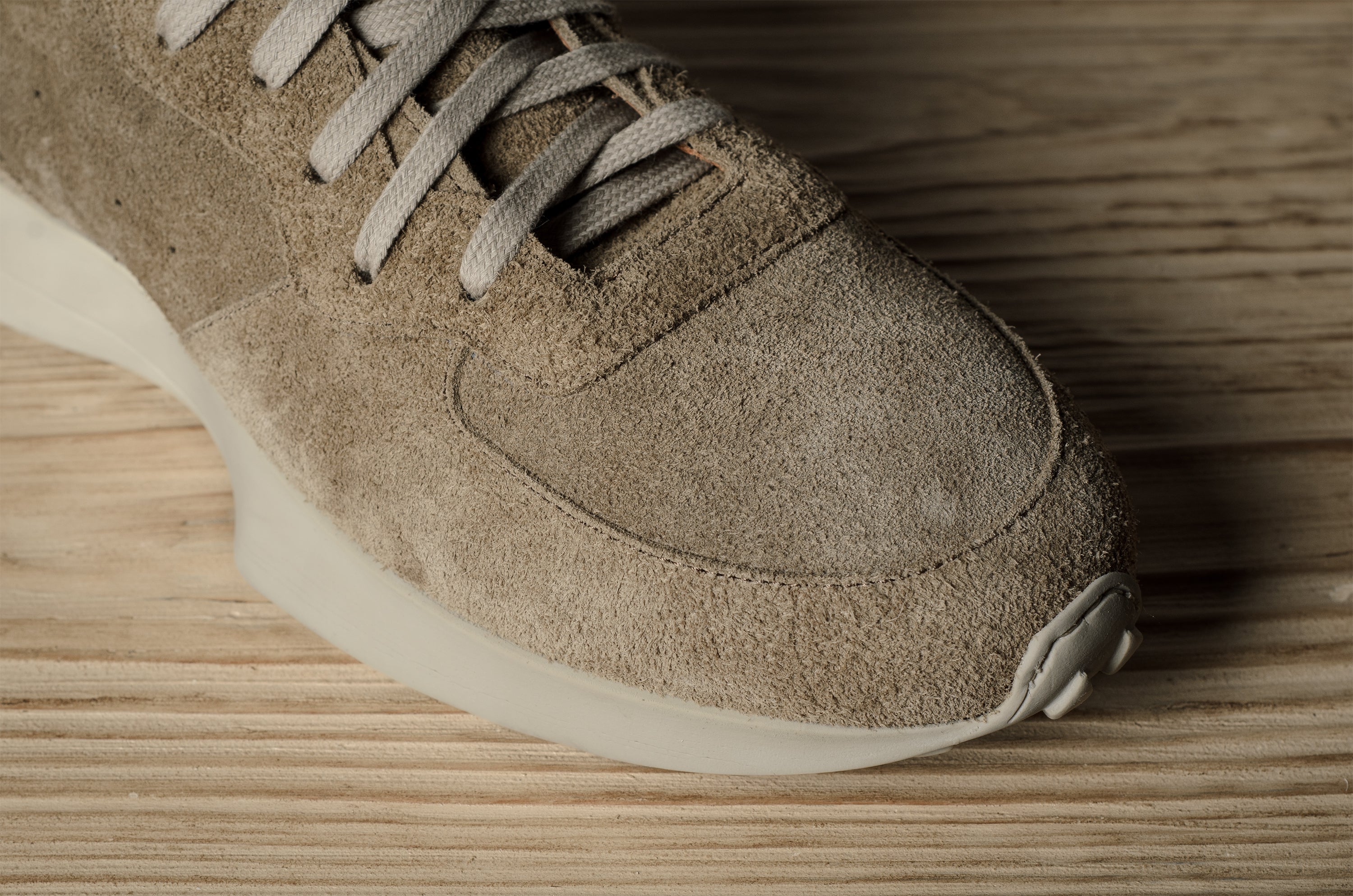 Brown suede sneaker on a wooden surface