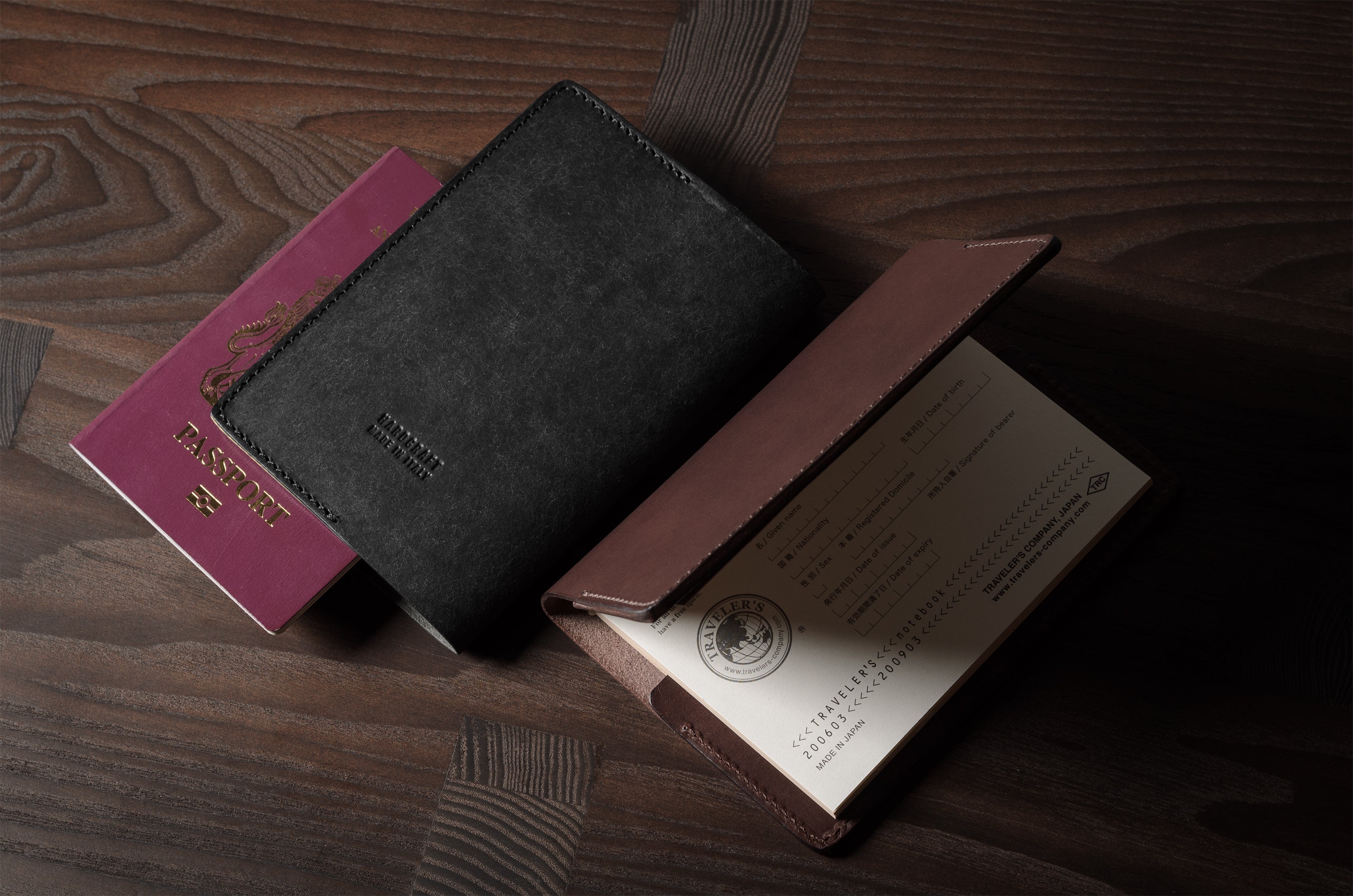 Black and brown leather passport cases on a wooden surface
