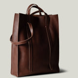 Brown leather tote bag on a light gray background