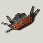 Multi-key pouch made of brown leather on a light gray background