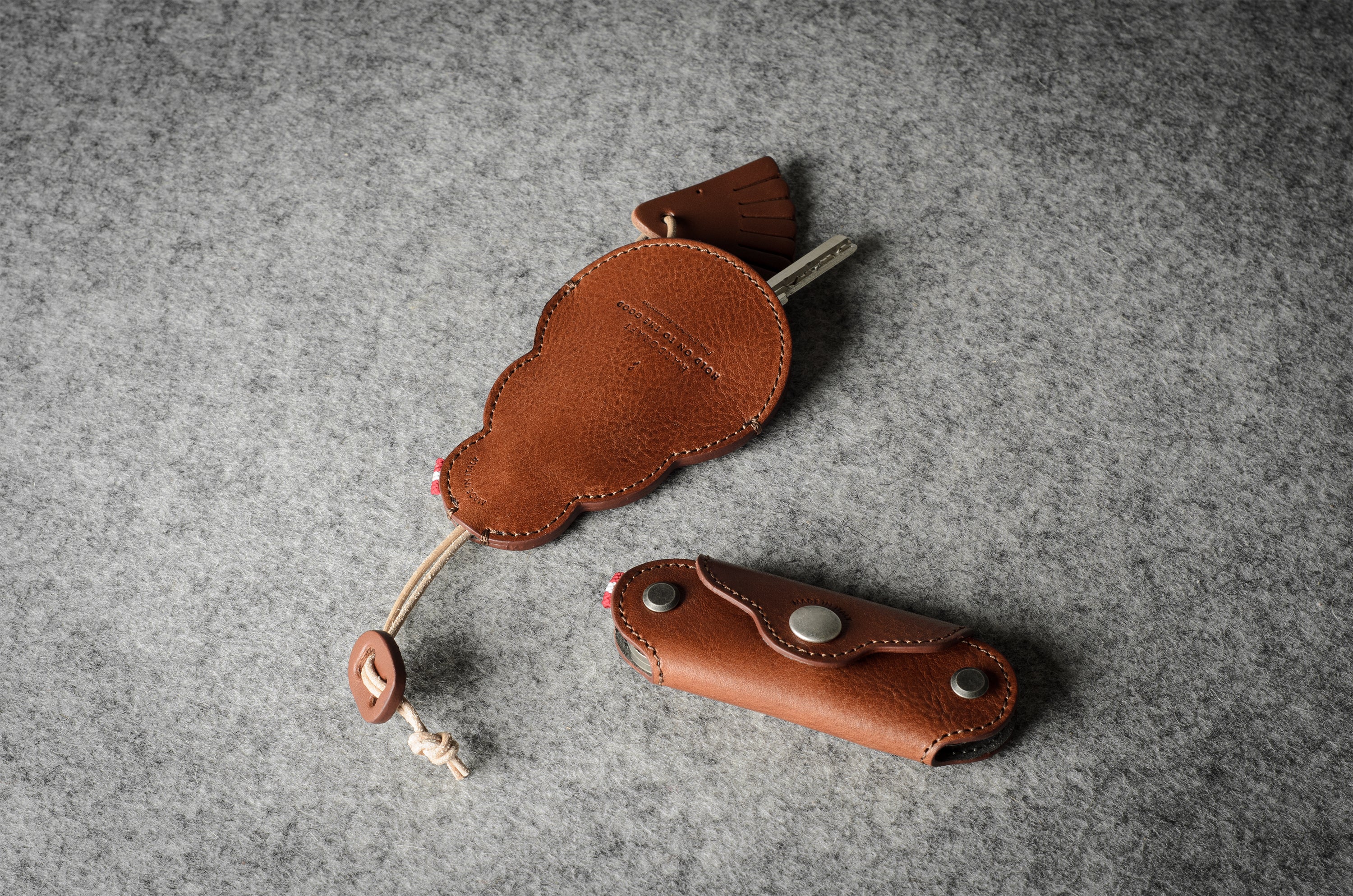 Multi-key pouch made of brown leather on a gray background