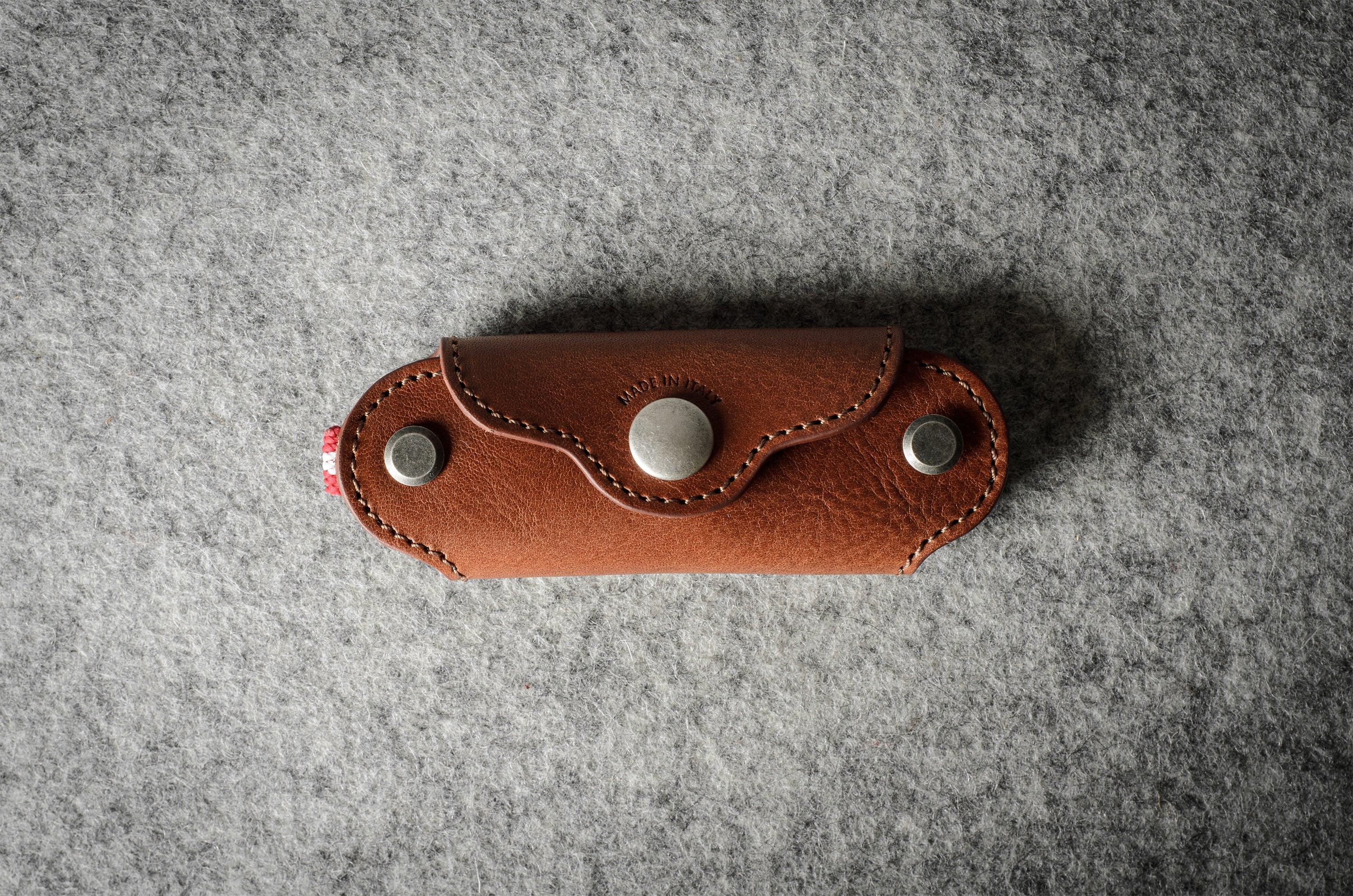 Multi-key pouch made of brown leather on a gray background