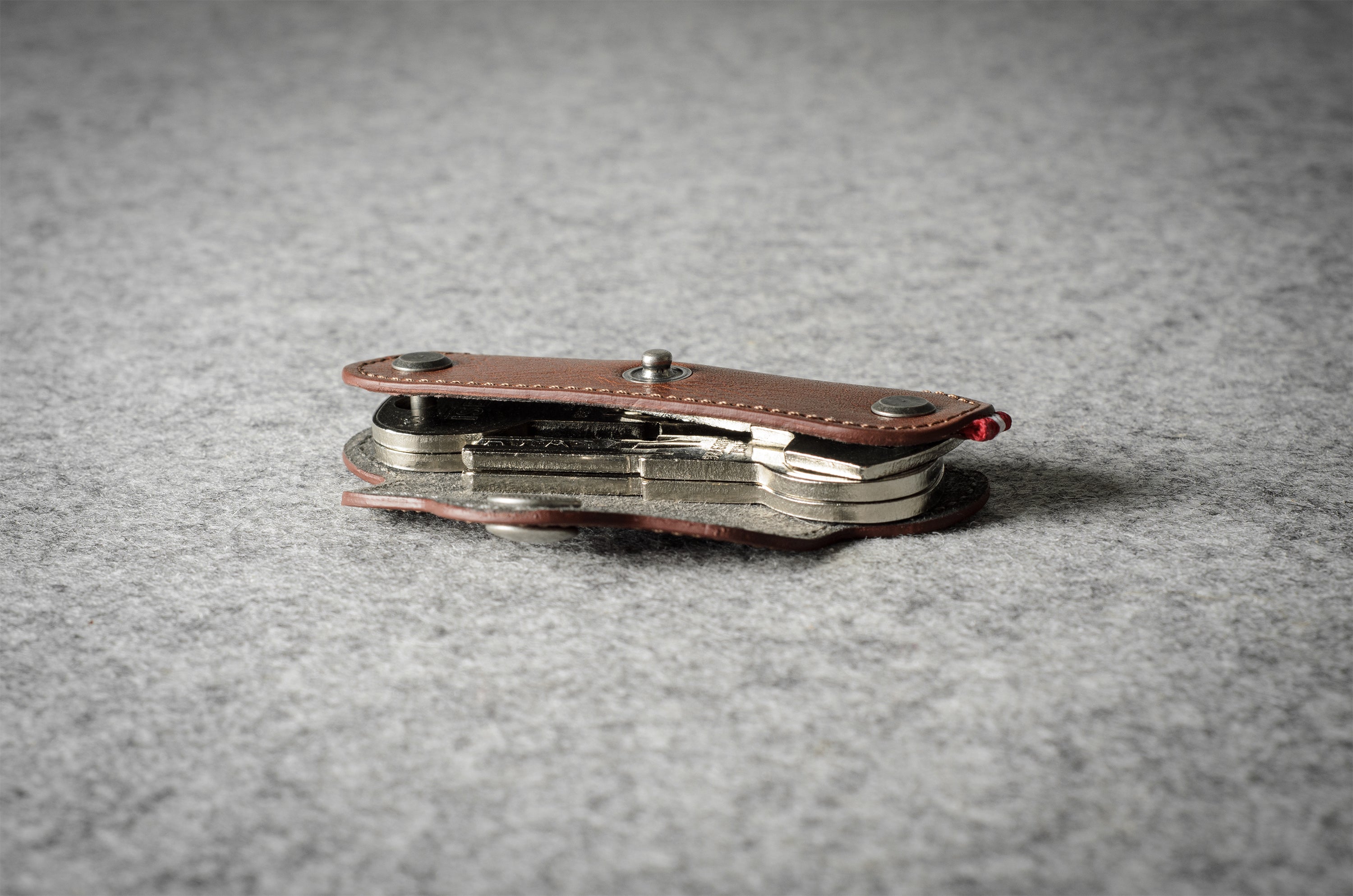 Multi-key pouch made of brown leather on a gray background