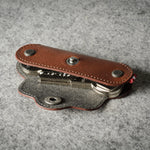 Multi-key pouch made of brown leather on a gray background