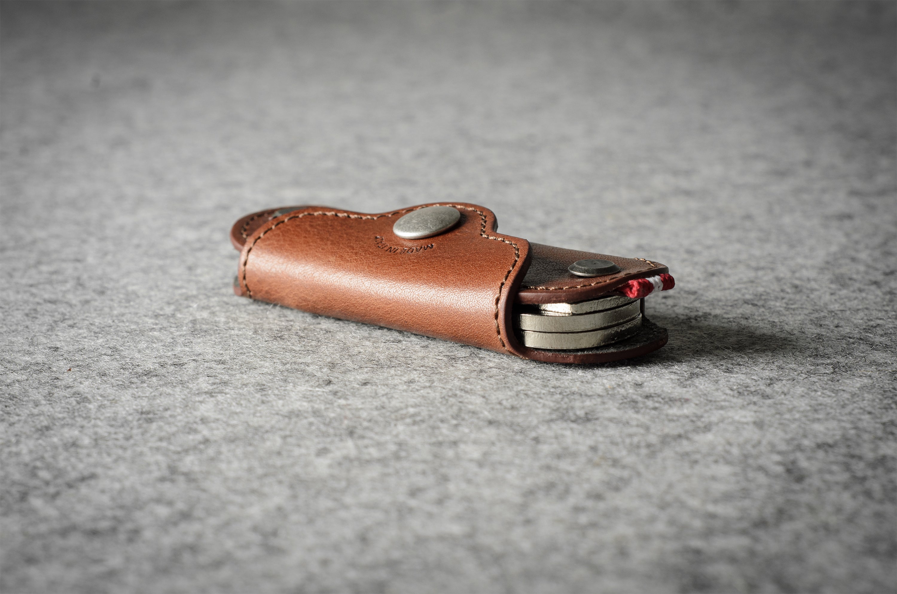 Multi-key pouch made of brown leather on a gray background